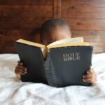 photo of child reading holy bible