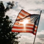 american flag under a cloudy sky